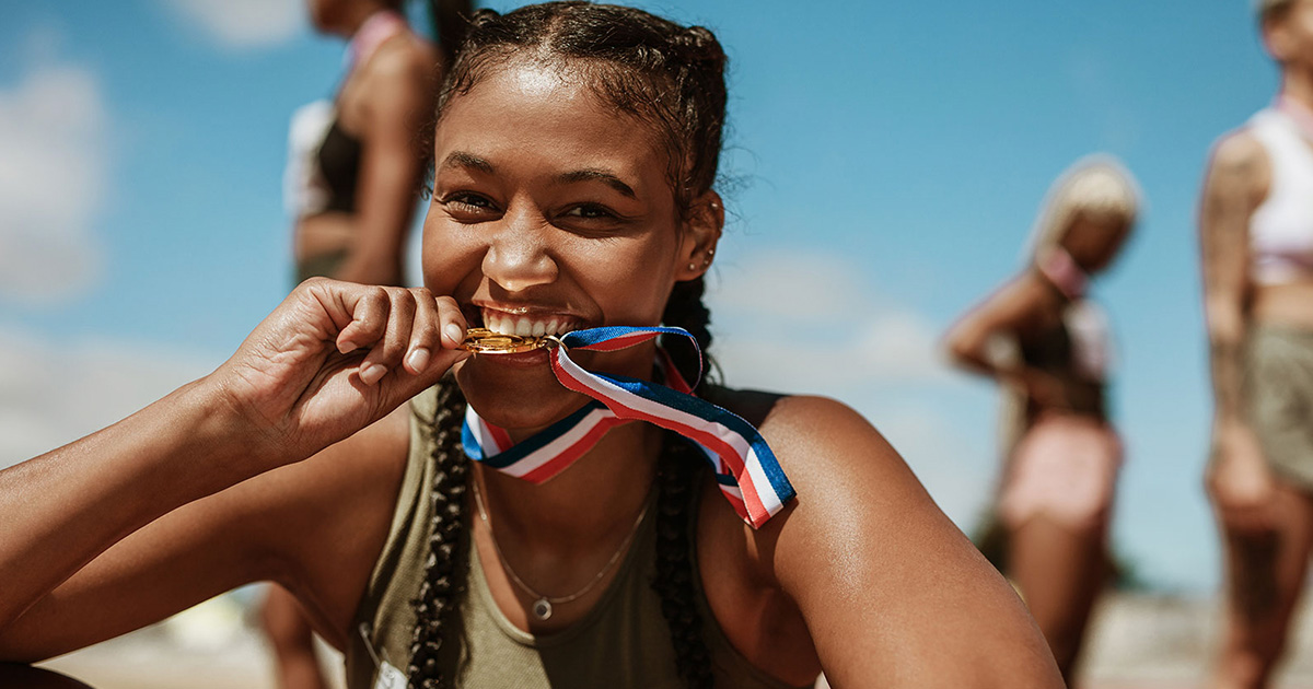 athlete biting on medal