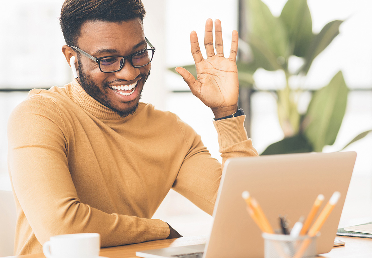 man waving at laptop