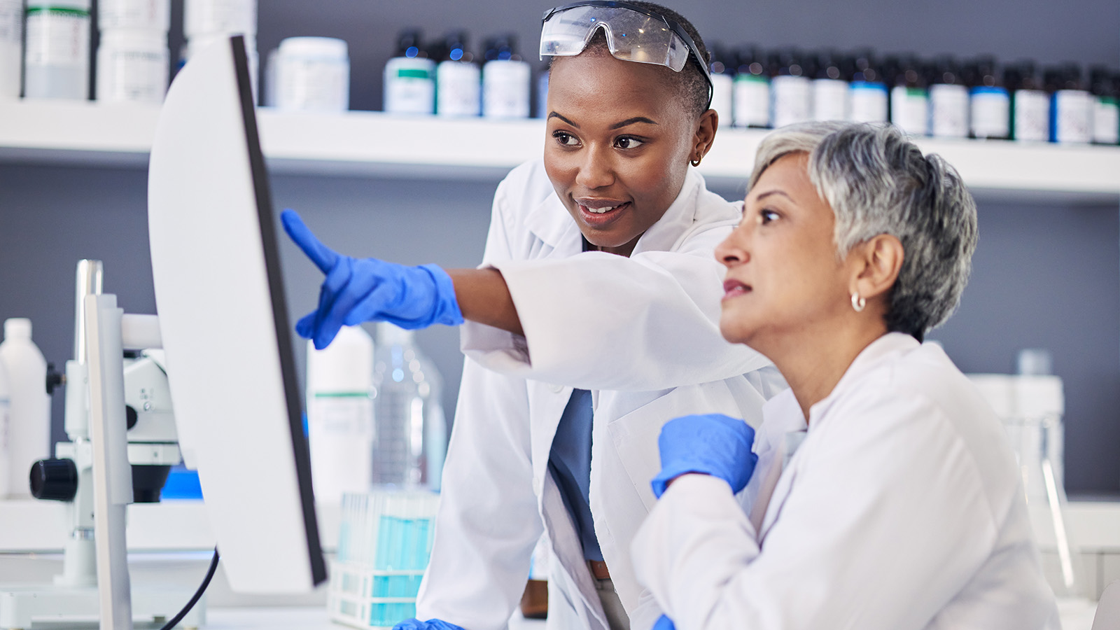 two colleagues discussing their work in a chemical laboratory